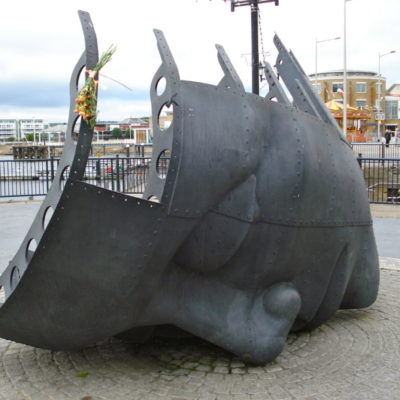 Photograph of Merchant Seaman's Memorial, a metal face on the hull of a ship in Cardiff